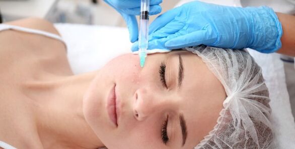 Une cosmétologue effectue une procédure de rajeunissement de la peau du visage avec du plasma. 